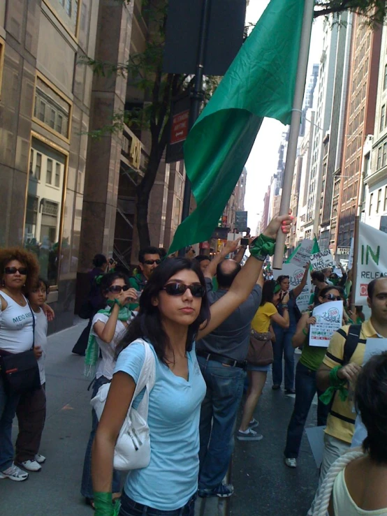 a woman holding a flag in the middle of a crowd