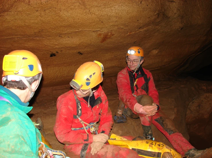 three men are dressed up in red safety gear