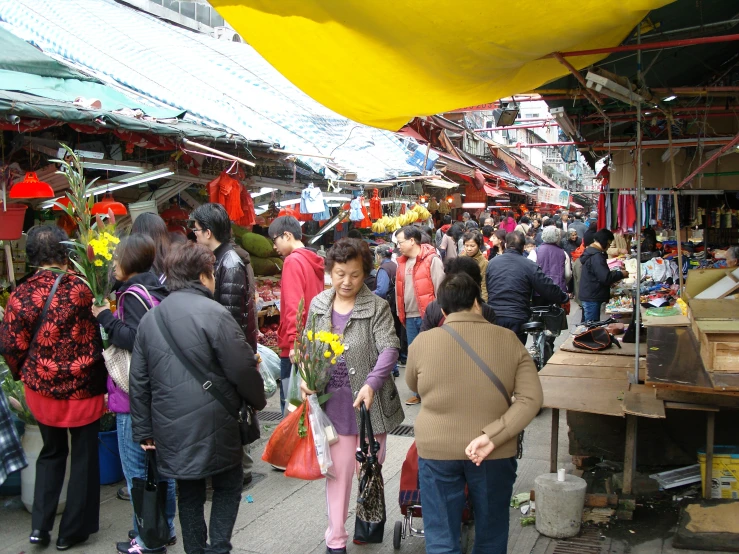 a market scene in a busy city with lots of stalls and flowers