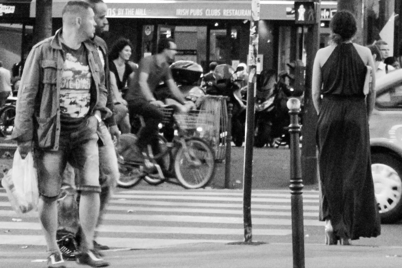 a man walking across a cross walk between two traffic signals