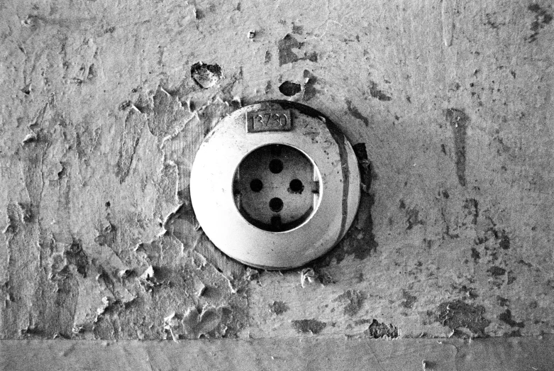 an old electrical outlet has three holes