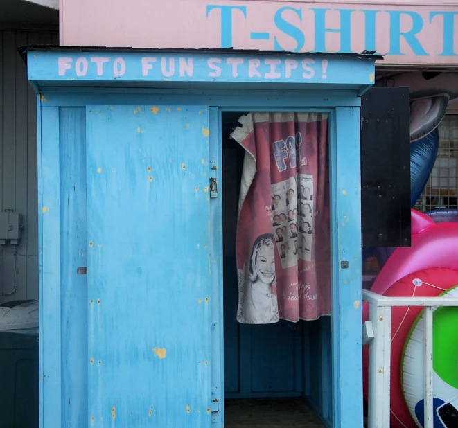 a blue door to a pink and white building that says tshirt