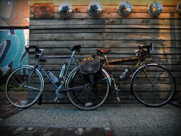 two bikes parked next to each other near a wall