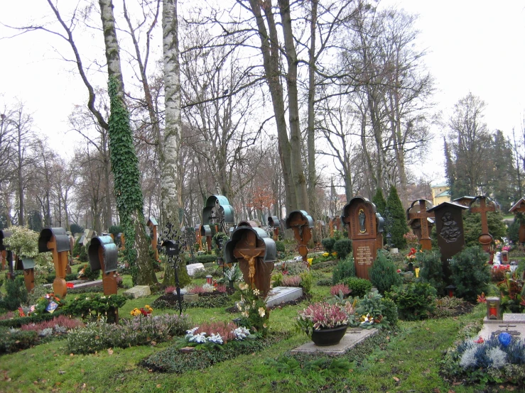 several different shaped and colored graves with trees in the background