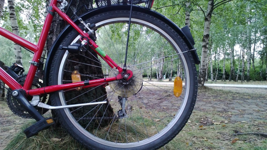 a red bicycle with a yellow bike tire hanging from the side of it