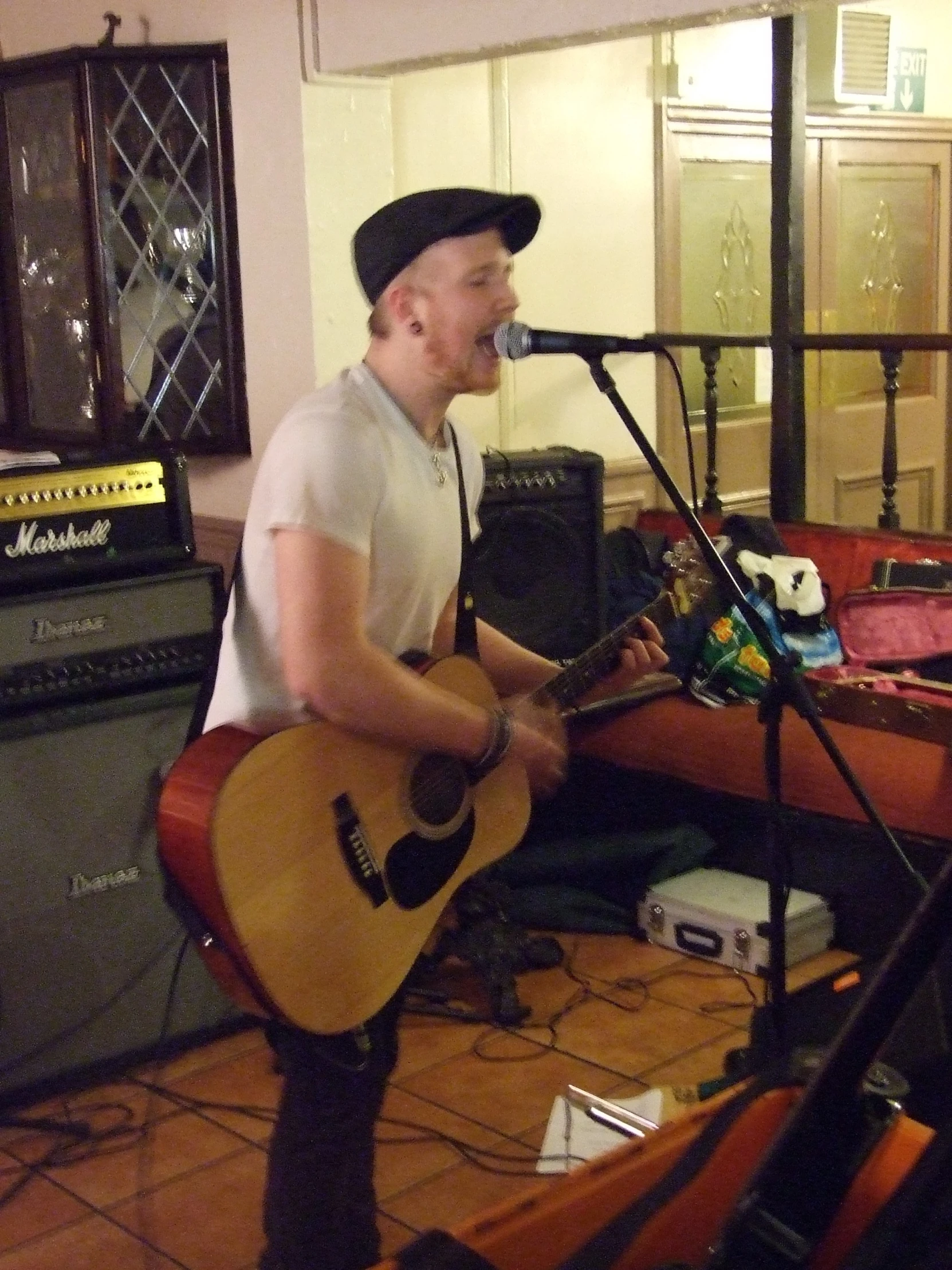 a man playing guitar and singing into a microphone