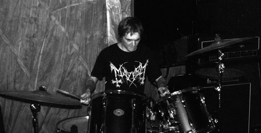 a man is playing drums in front of a microphone