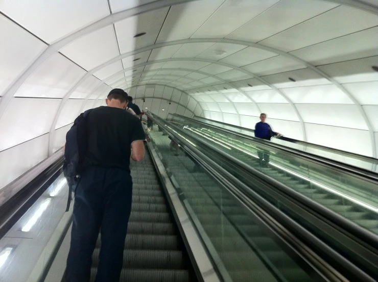 people riding down escalators at an indoor mall