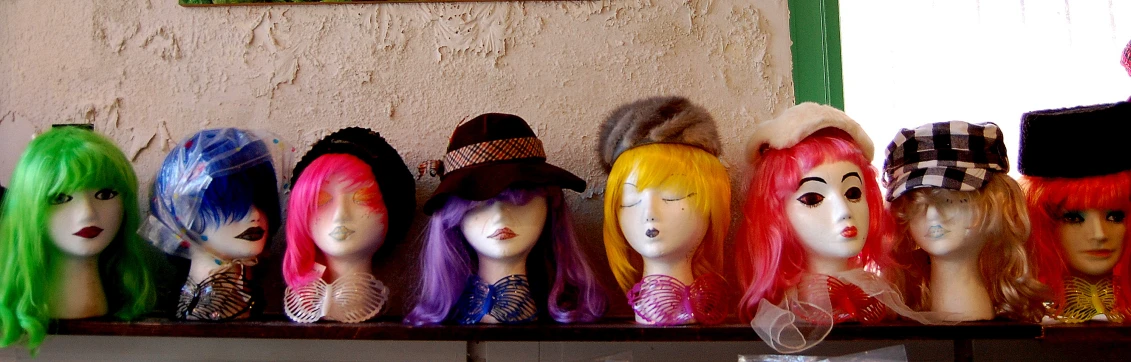 colorful wigs on display in front of a window