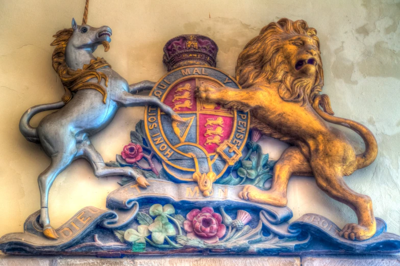 two lion and unicorn statues on display against a white wall