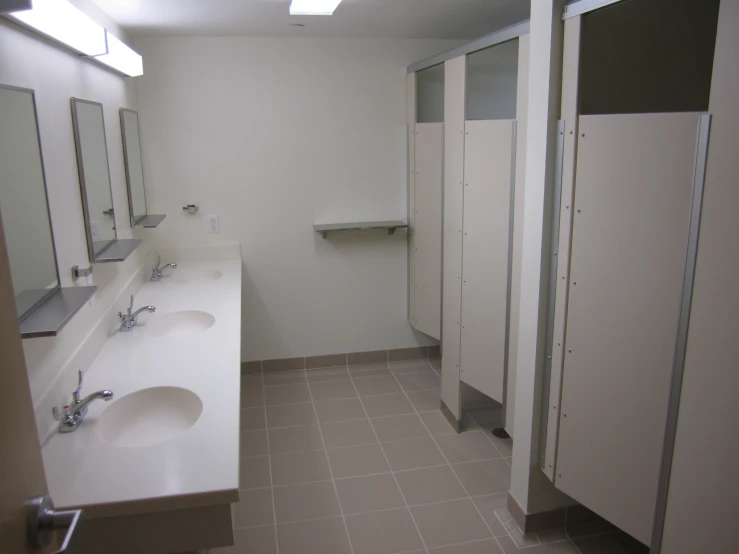 a restroom with multiple sinks and three mirrors