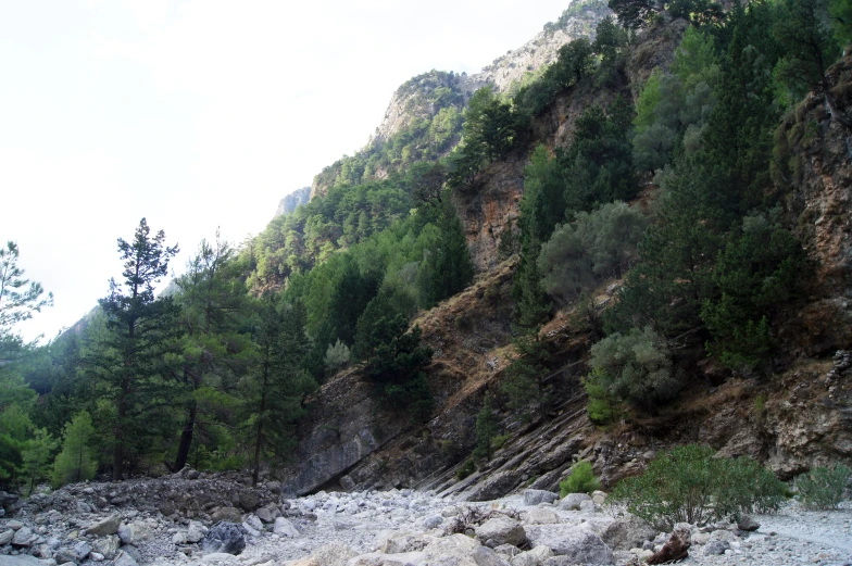 an empty river with large rocks near a cliff