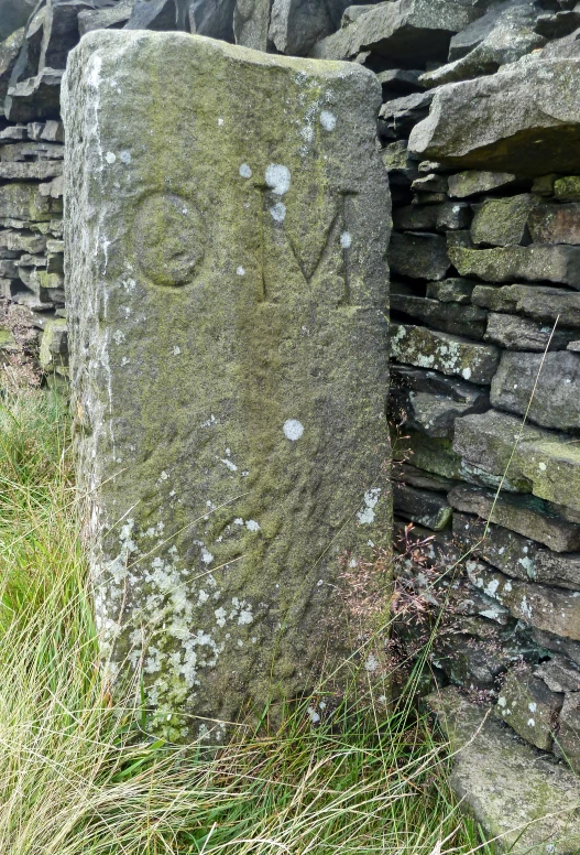 a stone statue sitting next to a wall