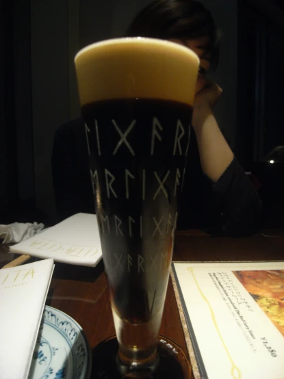 a tall glass with black writing on it