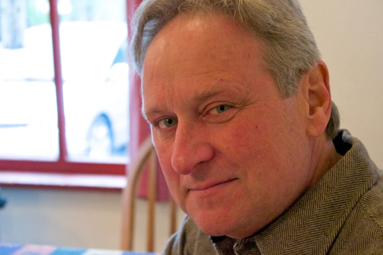 a man sitting in front of a wooden table