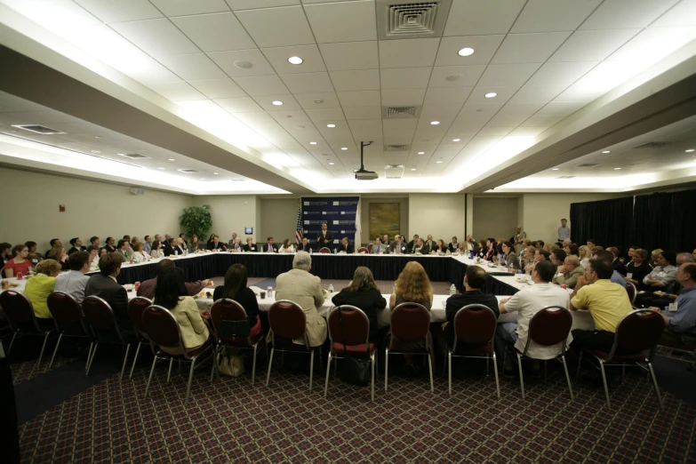 a conference room filled with people facing away from the camera