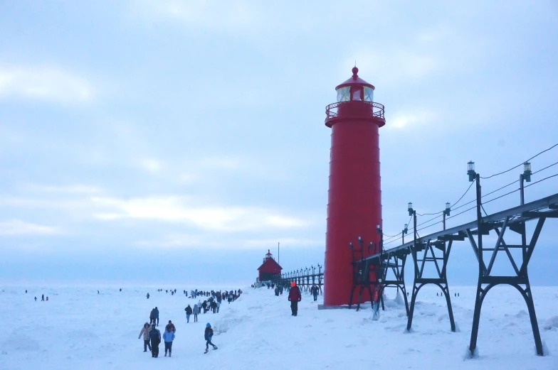 people walking near a red light tower in the snow