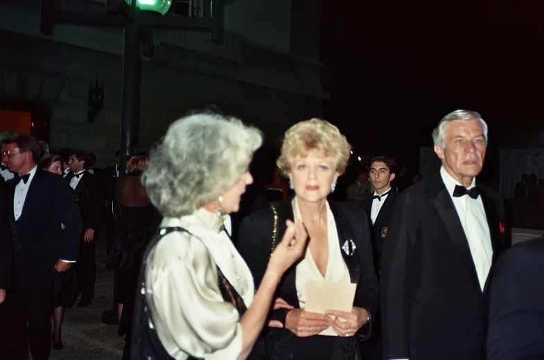 an older man is standing behind two older women