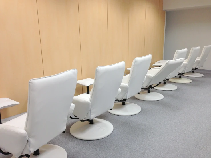 a row of white chairs sitting in an office