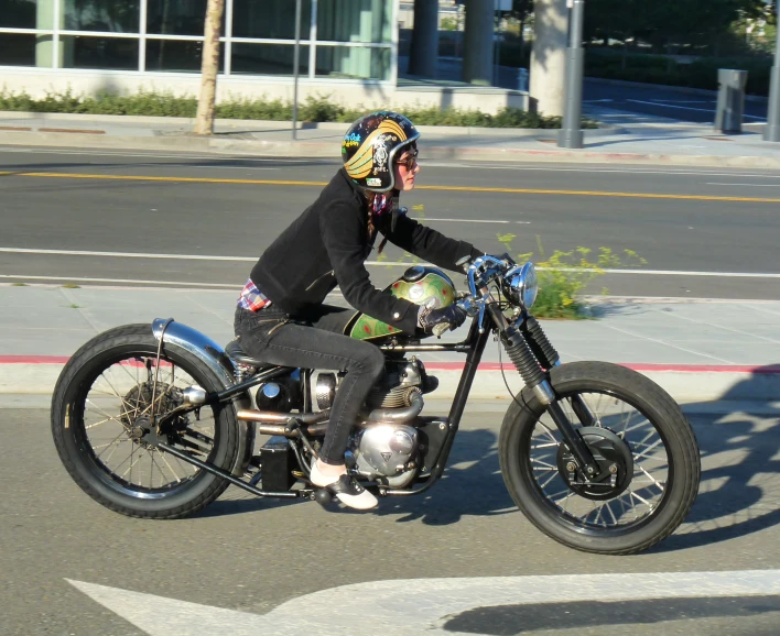 a man riding on the back of a motorcycle down a street