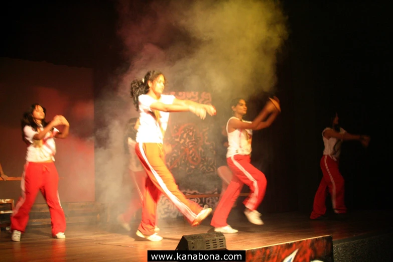 women performing on stage with smoke flying from the air