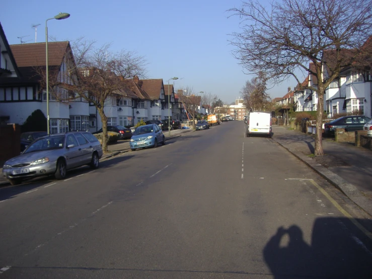 a view of the street with cars on both sides and a building on the other side of it