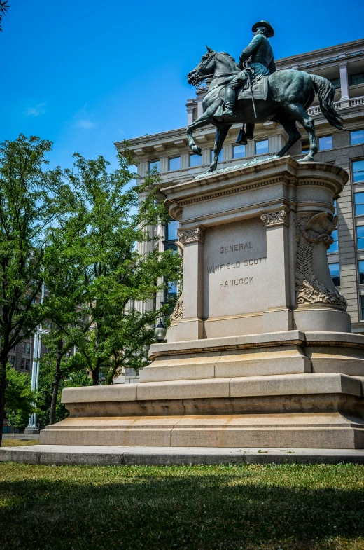 a statue on the corner in front of a tall building