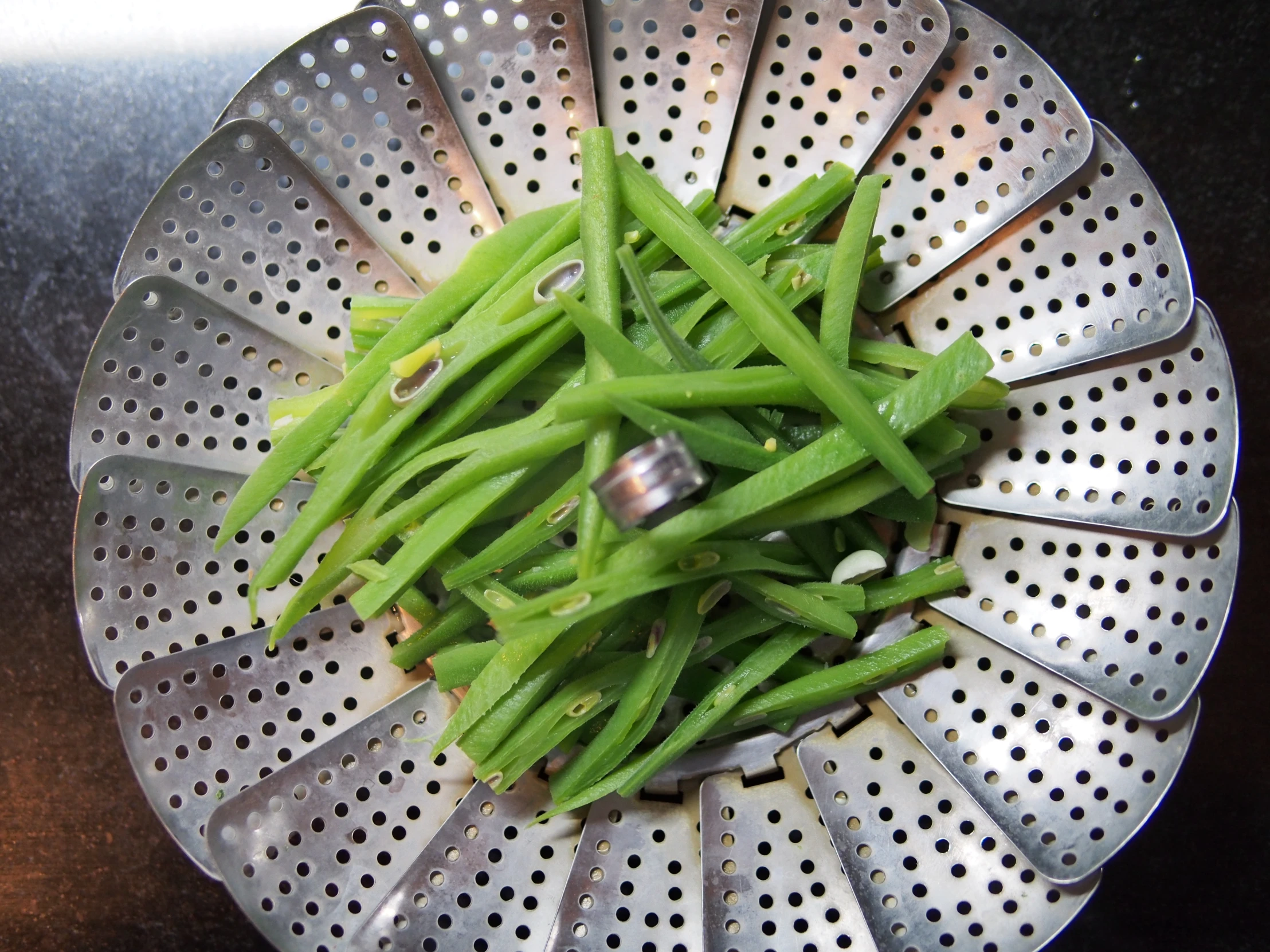 green beans and garlic in a colander on the table