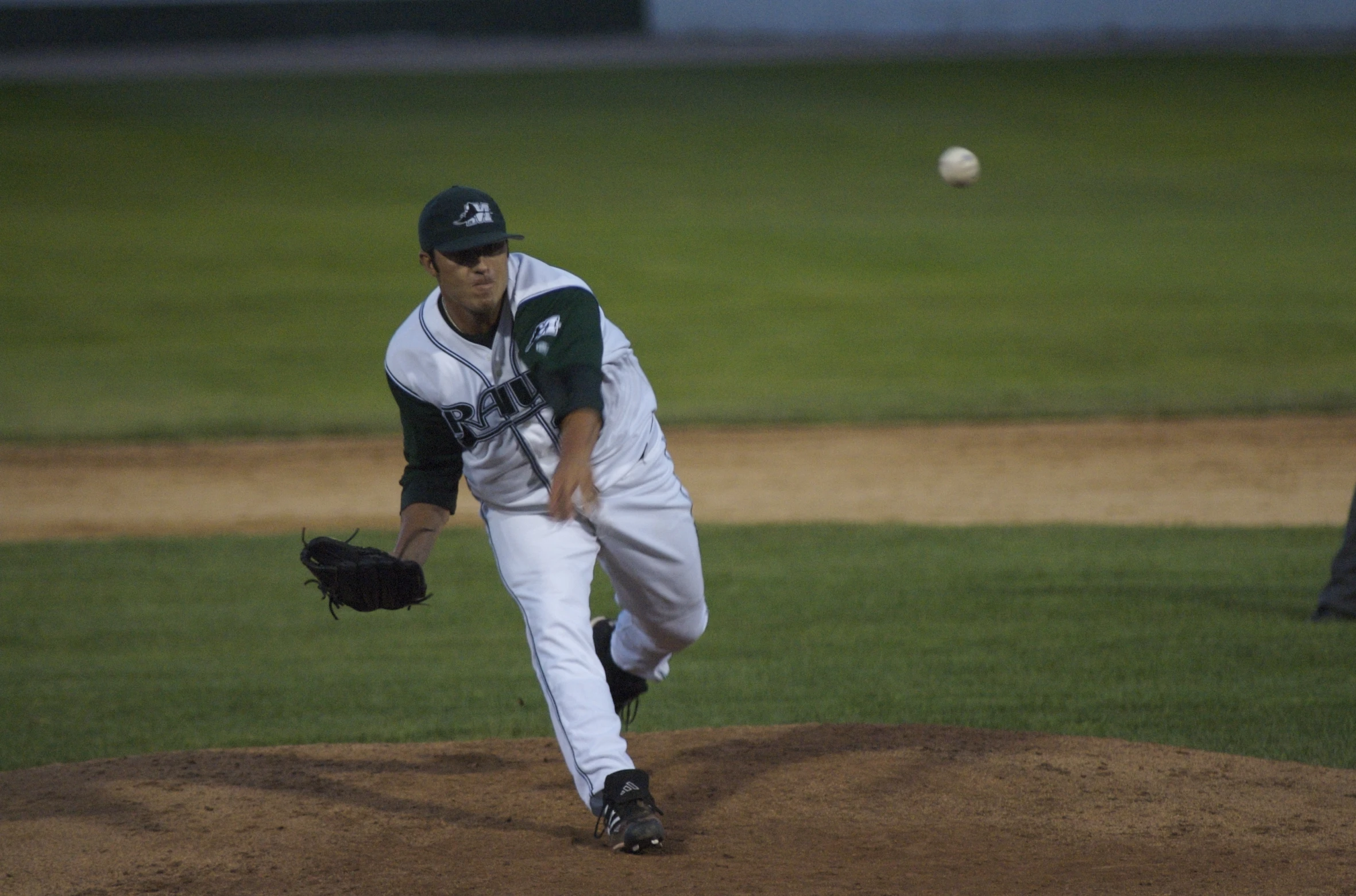 a baseball pitcher in the process of throwing a pitch