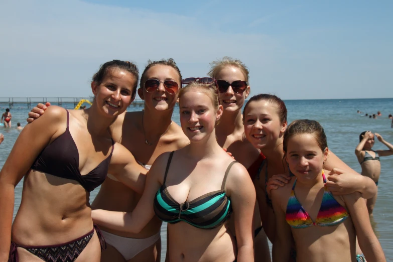 a group of women standing on top of a beach