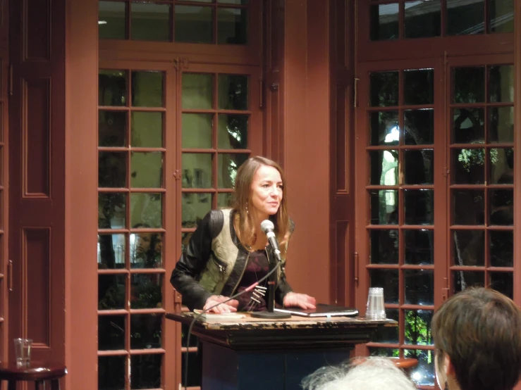 the woman is speaking at the podium with a microphone