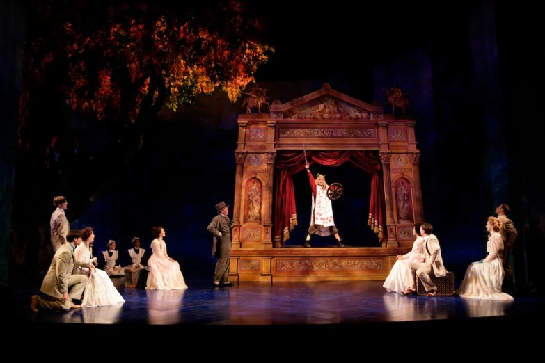 a stage with many actors dressed in elegant clothes