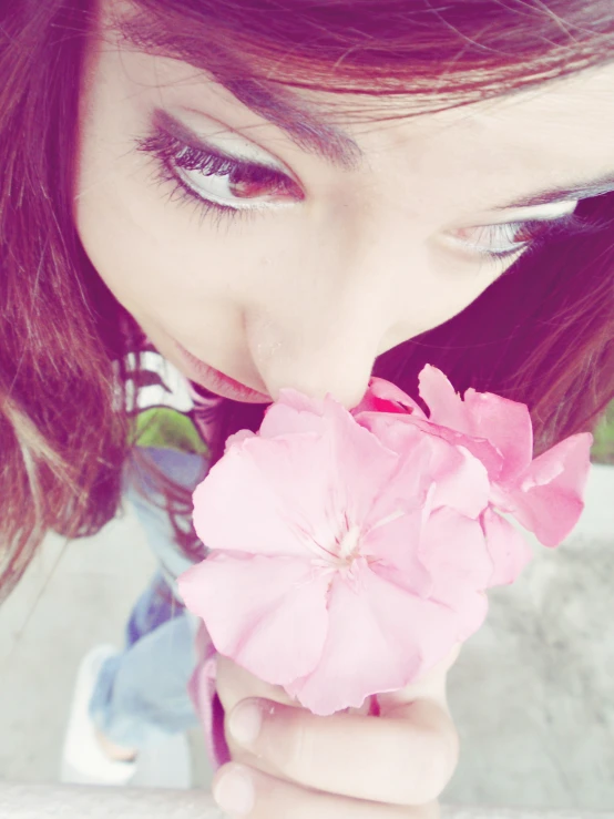 a woman wearing blue and pink holds flowers