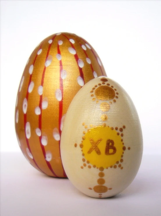 two painted eggs sitting side by side on a table