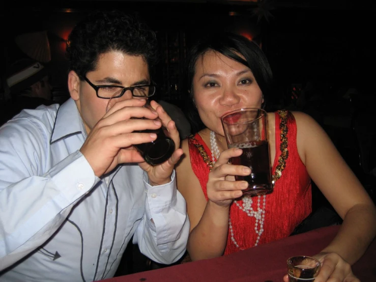 two people who are sitting down drinking soing
