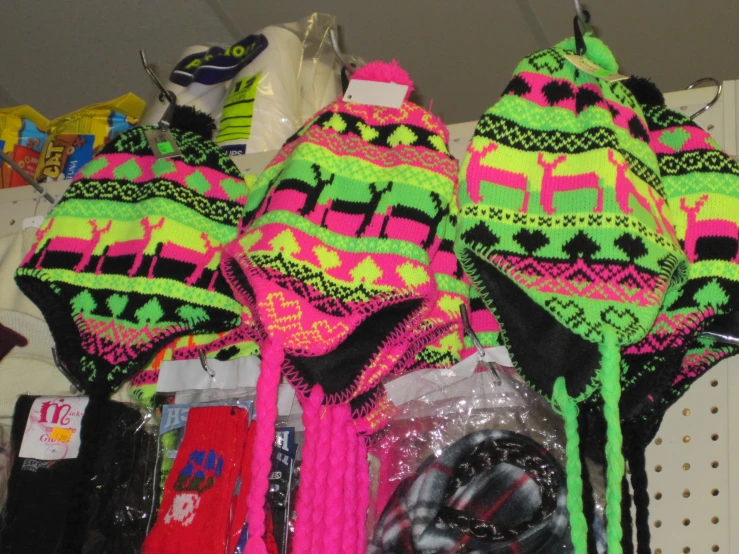 bright colored knitted hats and scarves displayed on hooks
