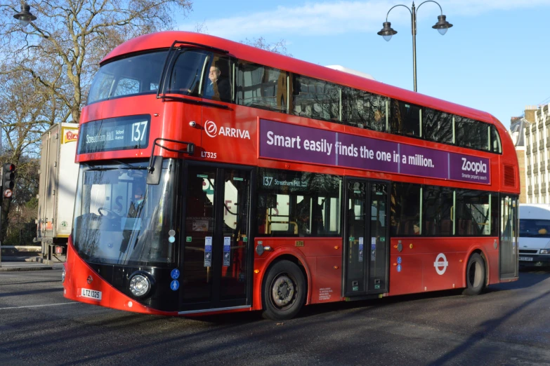 a large double decker bus is on the road