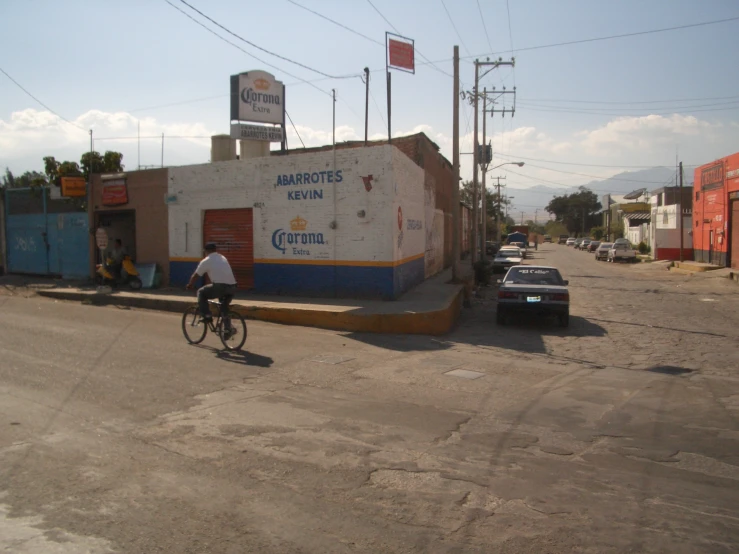 man on bicycle next to small building in urban area