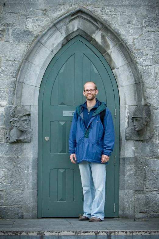 a man in blue coat standing outside a church