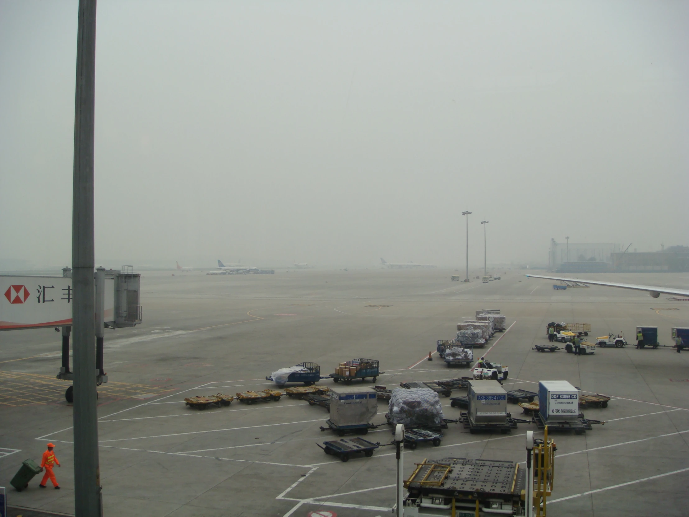 a plane and several trucks at the terminal