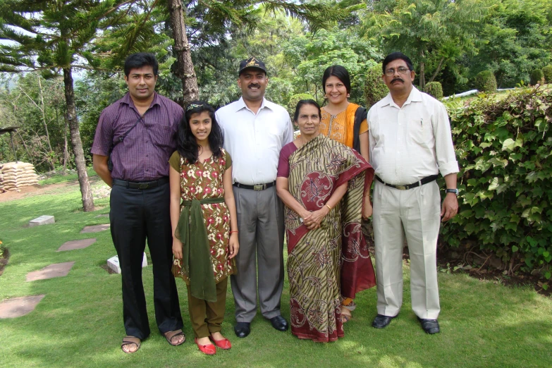 a group of people pose in the middle of grass