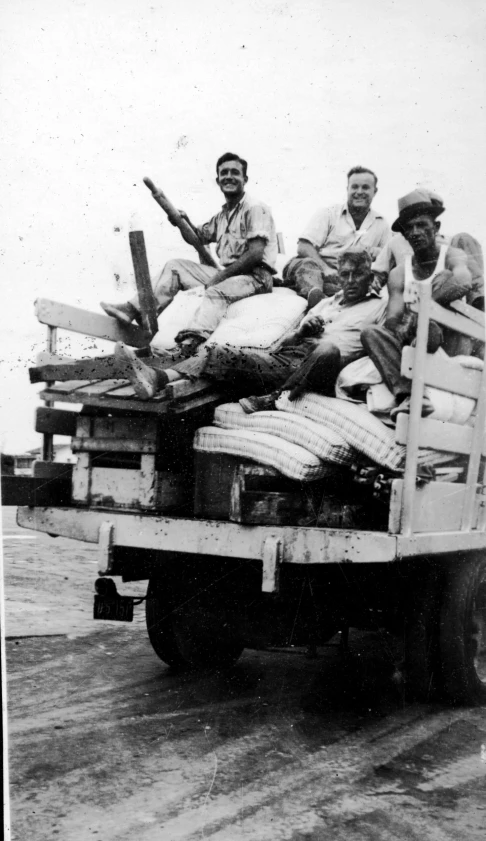 men are sitting on top of a large truck