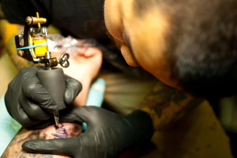 an old man having his arm done and tattoo done by a professional