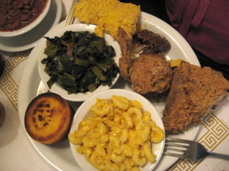 a platter of chicken and macaroni with two sides