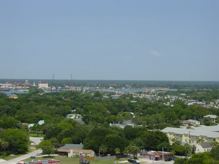 a lot of green trees and buildings near some water