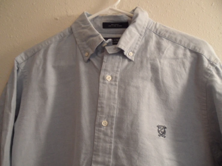 a white shirt with a small cat embroidered on it