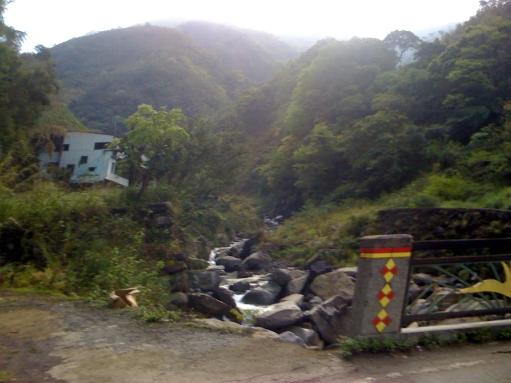 an open fire hydrant and some rocks by a house