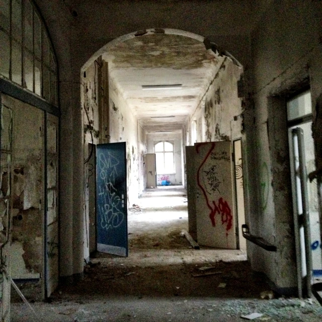 a hallway of an abandoned building covered in graffiti