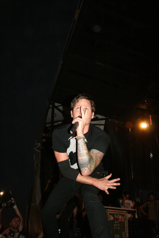 a young man singing into a microphone in front of a crowd