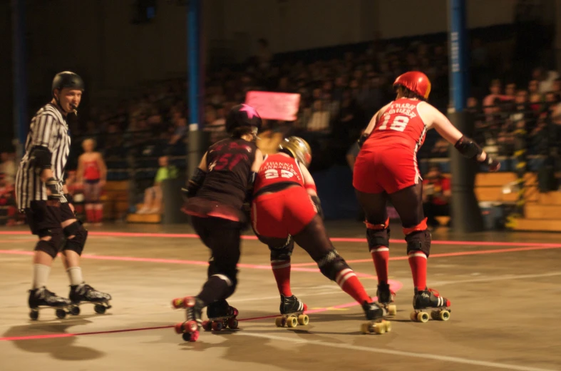 several people riding skate boards on a basketball court